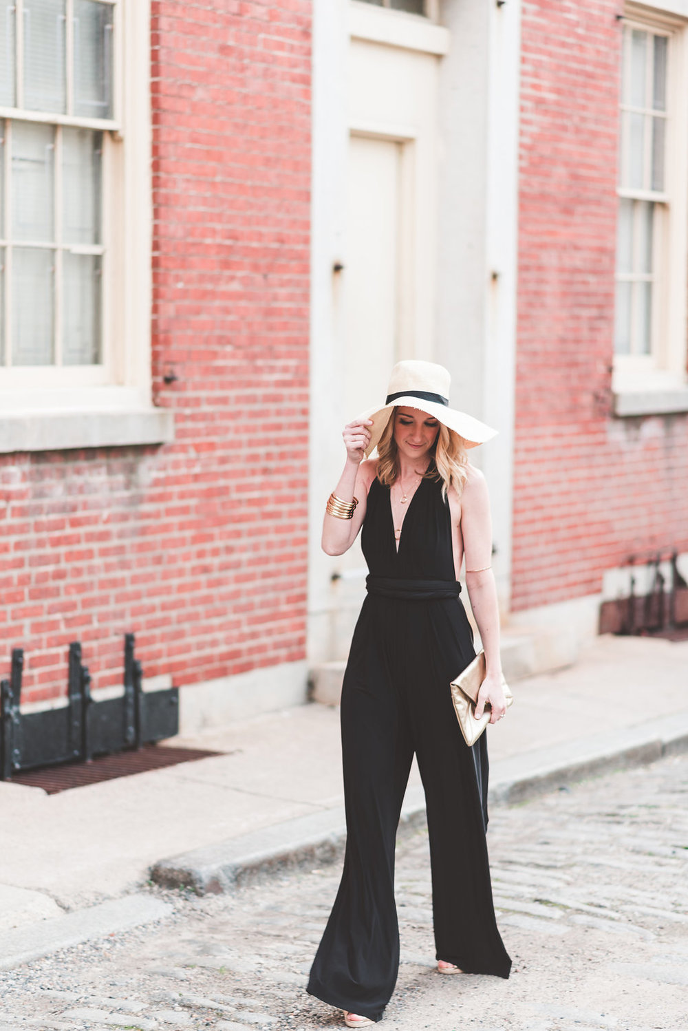 Woman walking in jumpsuit and hat